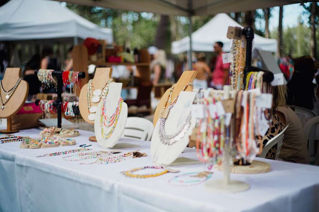 Jewelry stalls under white tents at an outdoor market