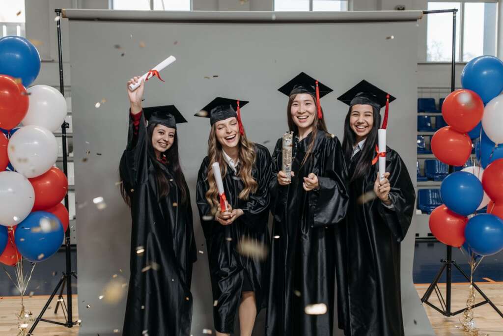 Graduates posing with balloons after the ceremony
