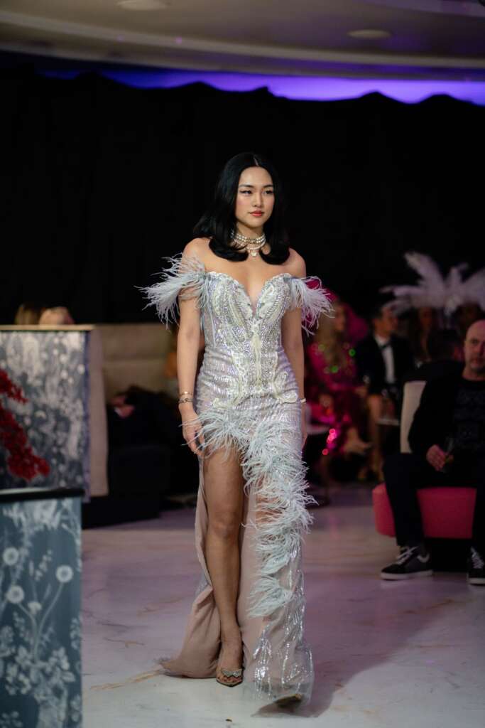 Model in an embellished gown walking through the crowd