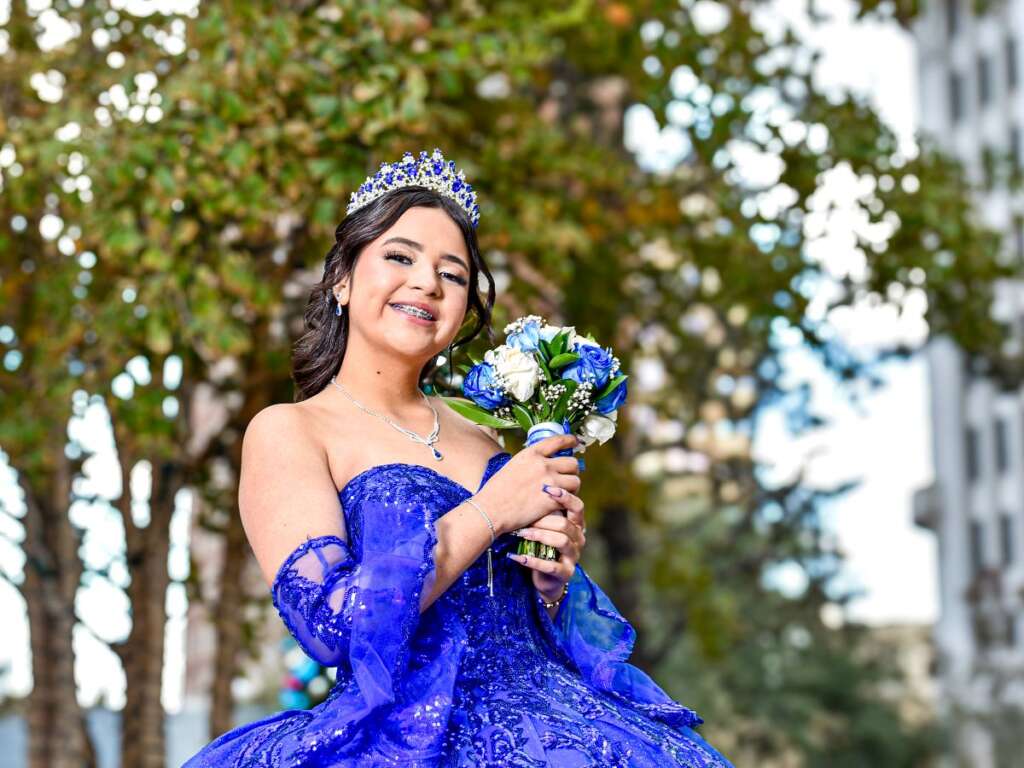 Quinceañera in a blue gown wearing her crown