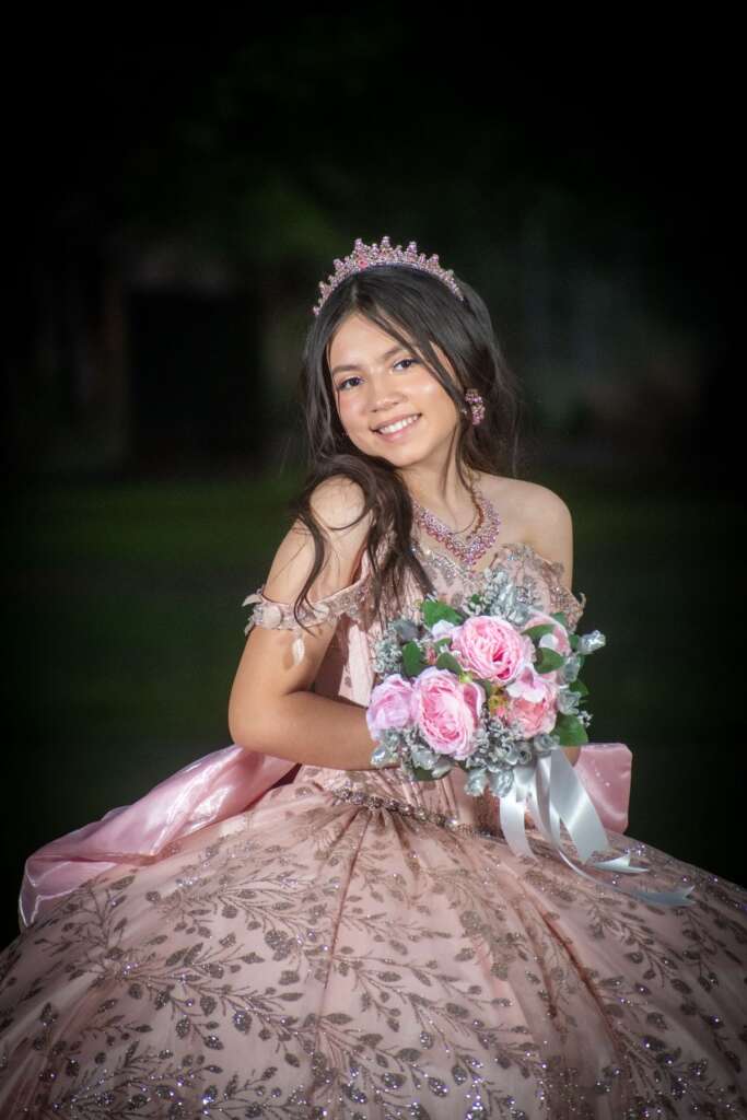 Quinceañera with tiara and bouquet of roses